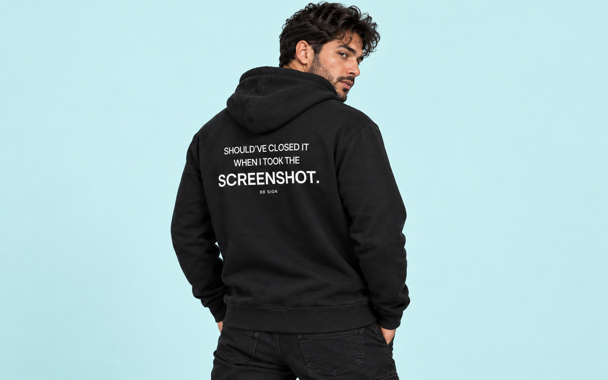 Model wearing the Screenshot Trader hoodie against a soft cyan studio backdrop